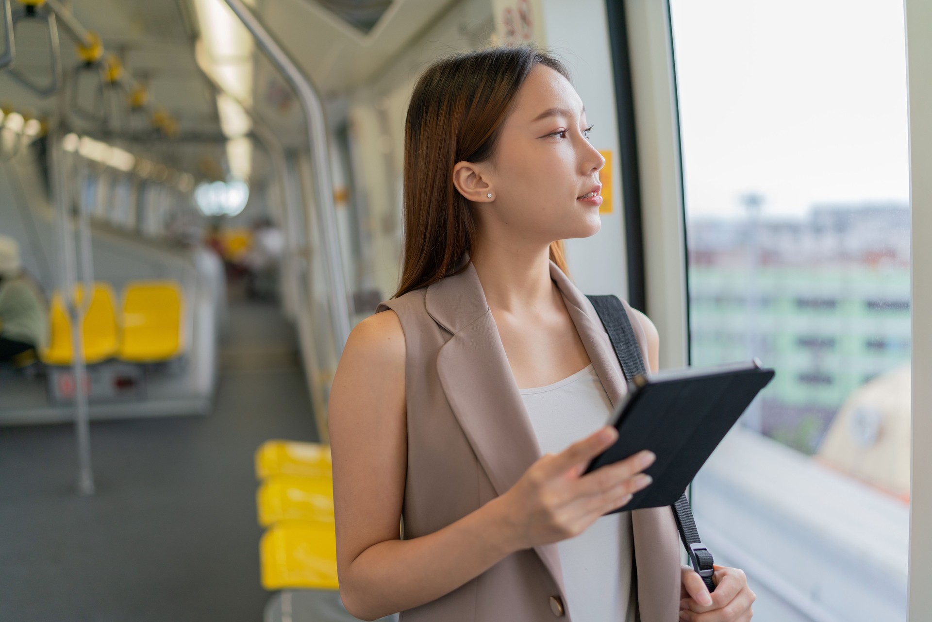 Urban Travel Lifestyle. A Connected Commuter. Asian Businesswoman on Monorail with Digital Tablet